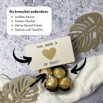 Du brauchst außerdem einen weißen Karton, Ferrero Rocher, kleine Klarsichttüten, Schere und Tesafilm.