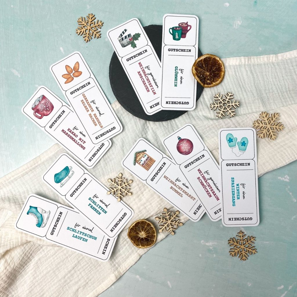 Foto von weihnachtlichen Gutscheinvorlagen zum Ausdrucken, mit Illustrationen von Glühwein, Weihnachtsbaum, Plätzchen, Eislaufschuhen und Kakao. Gutscheine mit Texten wie ‚für einen Glühwein‘, ‚für gemeinsam Weihnachtsbaum schmücken‘ oder ‚für einmal Schlittschuh laufen‘.“