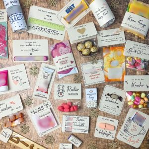 Viele kleine Weihnachtsgeschenke auf Holzhintergrund: Karten mit Schokolade, Süßigkeiten und liebevollen Botschaften wie „Rentiernasen“, „Schneemann Fürze“, „Gönne dir mal eine Auszeit“ und „Für meinen Lieblingsmenschen“. DIY Druckvorlagen als kleine Geschenke zu Weihnachten zum Ausdrucken.