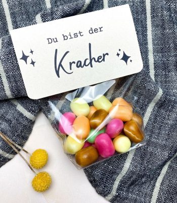 Fertige MAOAM Kracher Geschenkidee mit Etikett „Du bist der Kracher“ und bunten Bonbons in Klarsichttüte – liebevoll gestaltete DIY Vorlage zum Ausdrucken.